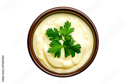 White ceramic bowl containing creamy sauce, garnished with fresh parsley leaves, on white background. Concept of fresh and delicious food