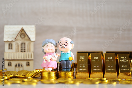 Mutual fund,Love couple senior on gold bar and stack of gold coin money on wooder background, Save money for prepare in future and pension retirement concept photo