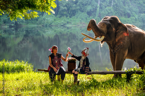 Photos Man and woman in traditional hilltribe clothing with elephant in animal conserva