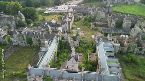 Haunted Denbigh Lunatic Asylum, North Wales, aerial pull back from near revealing scenery, sunny afternoon photo