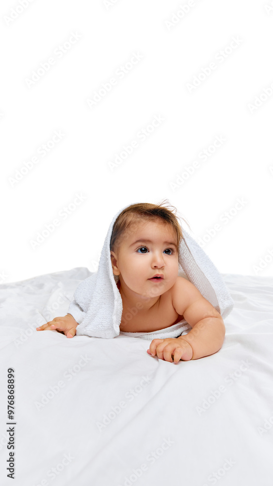 Peeking from under soft white towel, baby girl looks ahead with curiosity, capturing purity of her playful and innocent nature. Concept of beauty, parenthood, childhood, life and birth. Peeking from under soft white towel, baby girl looks ahead with curiosity, capturing purity of her playful and innocent nature. Concept of beauty, parenthood, childhood, life and birth.