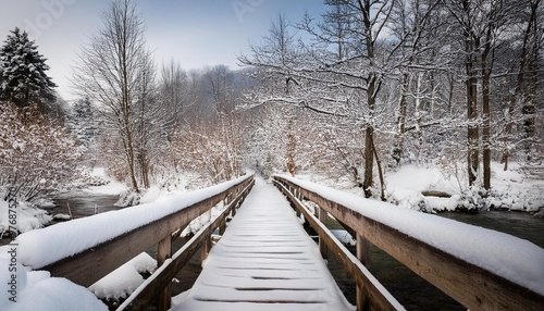 Snow-covered wooden footbridge over a creek