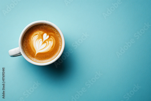 White cap of cappuccino with milk foam on bright blue turquoise background. Flat lay with black hot coffee mug. Coffee love minimal trendy concept. top view backdorp with copy space. photo