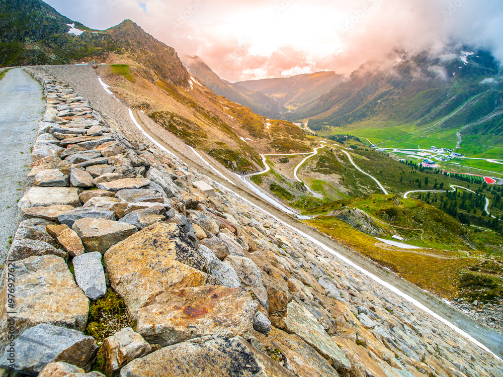 Φωτογραφία Overlooking the Finstertal Dam in Kuhtai, the landscape revels in the lush colors of spring with winding roads cradling the valley amidst cloudy skies
