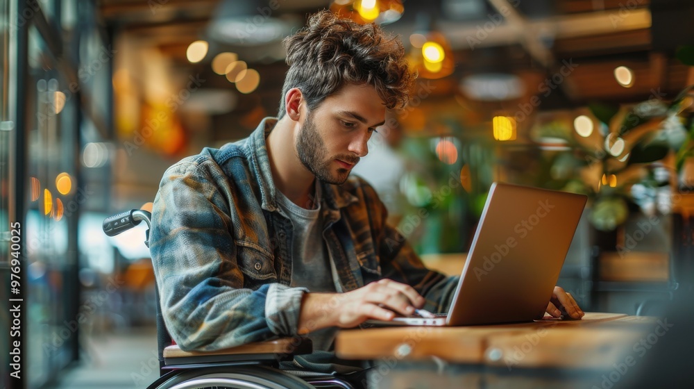 A young man in a wheelchair working on a laptop, engaged in a brainstorming session with his team. A young man in a wheelchair working on a laptop, engaged in a brainstorming session with his team.
