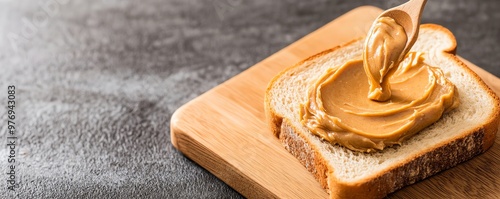 Delicious peanut butter being spread on fresh bread, perfect for breakfast or snack options.