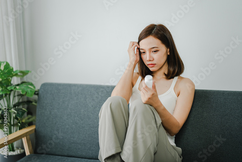 A young woman is sick and dependent on medicine. Young woman takes migraine medicine to relieve symptoms Have a headache and high fever from being sick Health concept