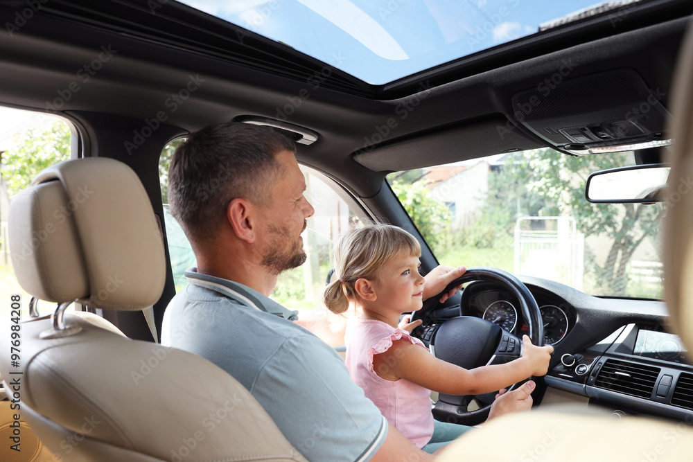 Man with daughter holding steering wheel inside car Man with daughter holding steering wheel inside car