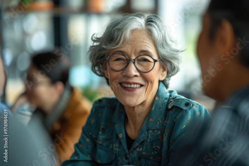 Smiling Elderly Woman in Glasses Having a Conversation at a Cozy Cafe