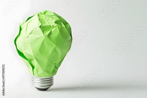 A crumpled green paper light bulb on a brown background photo