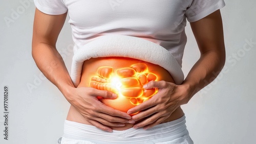 A person experiencing abdominal discomfort, hands on belly with glowing illustration, representing pain relief and wellness.