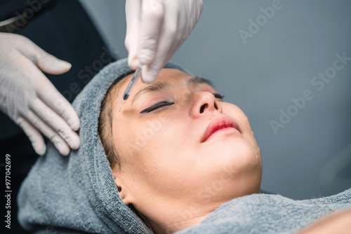 surgery doctor injecting asian woman filler in face skin. surgeon nurse putting medicine through needle into patient skin. pretty patient got facial therapy injection using needle by medical staff