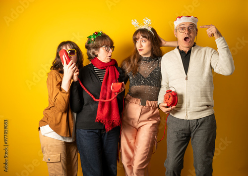 Group of people in festive attire posing with props against a yellow background photo