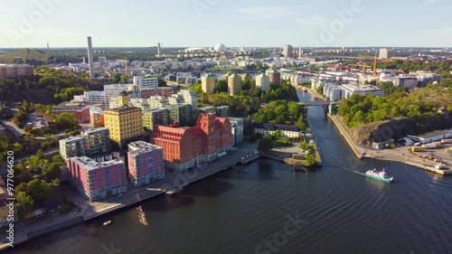 Stockholm, Sweden. The old industrial area of Saltsjöqvarn, Danvikstull and bridge, Globen and Hammarby sjöstad, boats passing by, clear sky, late summer.