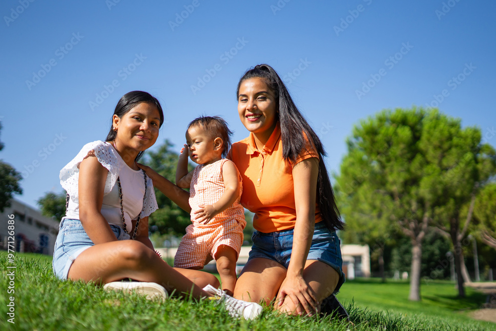 Portrait of a Latina baby with her young mother and teenage aunt in a park on a sunny day Portrait of a Latina baby with her young mother and teenage aunt in a park on a sunny day