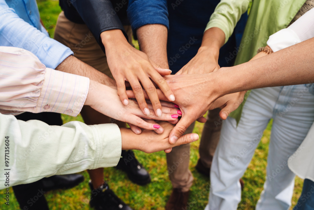 Diverse group stacking hands outdoors showing unity teamwork and collaboration Diverse group stacking hands outdoors showing unity teamwork and collaboration