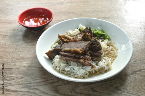 braised  slice cow leg stew black Chinese herb soup eat couple boiled Chinese kale on plain rice in plate dipping spicy sour chili sauce