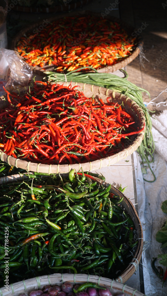 Pile of red chilies, green chilies and cayenne peppers in a bamboo basket. Focus selected Pile of red chilies, green chilies and cayenne peppers in a bamboo basket. Focus selected