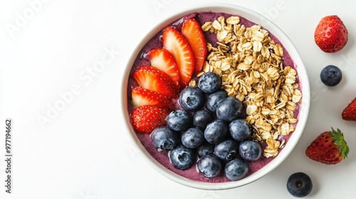 A beautifully arranged acai bowl featuring fresh strawberries, blueberries, and granola, set against a plain white background