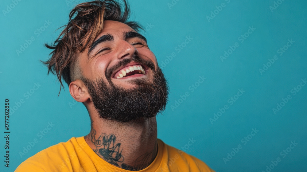 © ChubbyCat - Happy Male Student,  A joyful young man with a stylish haircut and beard laughs heartily, showcasing his positive mood and satisfaction with life © ChubbyCat - Happy Male Student,  A joyful young man with a stylish haircut and beard laughs heartily, showcasing his positive mood and satisfaction with life