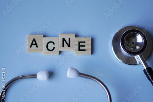 ACNE, wooden blocks with letters and stethoscope with light blue background. medicine concept