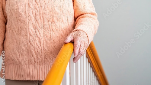 Fototapeta Naklejka Na Ścianę i Meble -  Elderly person holding onto a handrail while descending stairs, with careful steps, safety, fall prevention