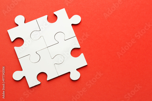 White puzzle pieces on red background, top view. Space for text