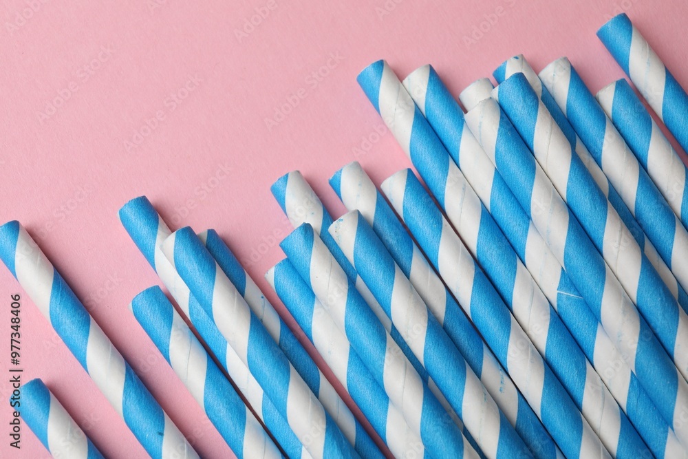 Fototapeta premium Bamboo drinking straws on pink background, top view