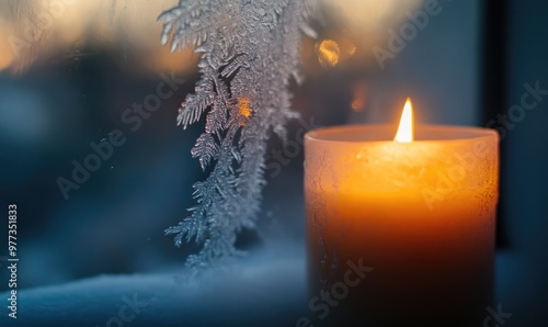 A candle is lit in front of a frosted window