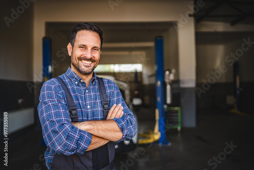 Car mechanic smile confidently with car in background at shop