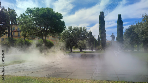 Brumisateur dans un le jardin public de la coulée verte du Paillon à Nice avec une statue d'Apollon