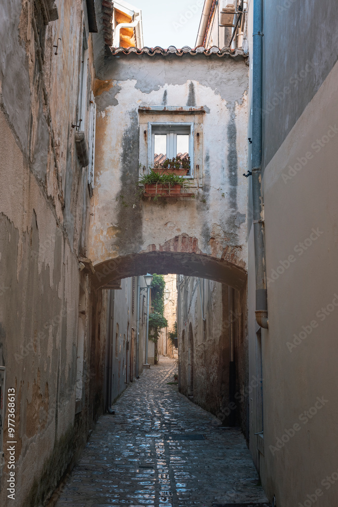 Narrow street with an arch and in the old town of Krk, Croatia Narrow street with an arch and in the old town of Krk, Croatia