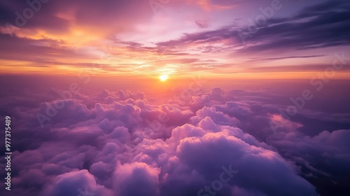 A stunning aerial view of soft clouds from an airplane, with the sky transitioning into warm hues of orange and purple during sunset