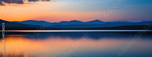 Sunset over a tranquil lake with mountains in the distance. Nature background. Travel banner