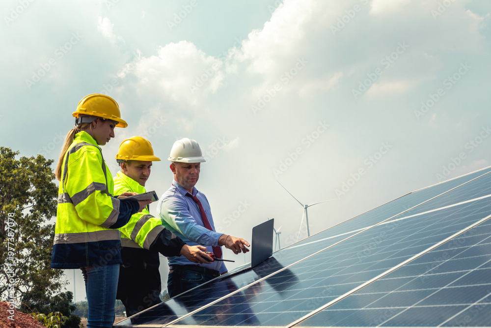 A team of professional electric engineers survey and inspect solar panels installation on wind farms. Sustainable renewable energy for the future, teamwork A team of professional electric engineers survey and inspect solar panels installation on wind farms. Sustainable renewable energy for the future, teamwork