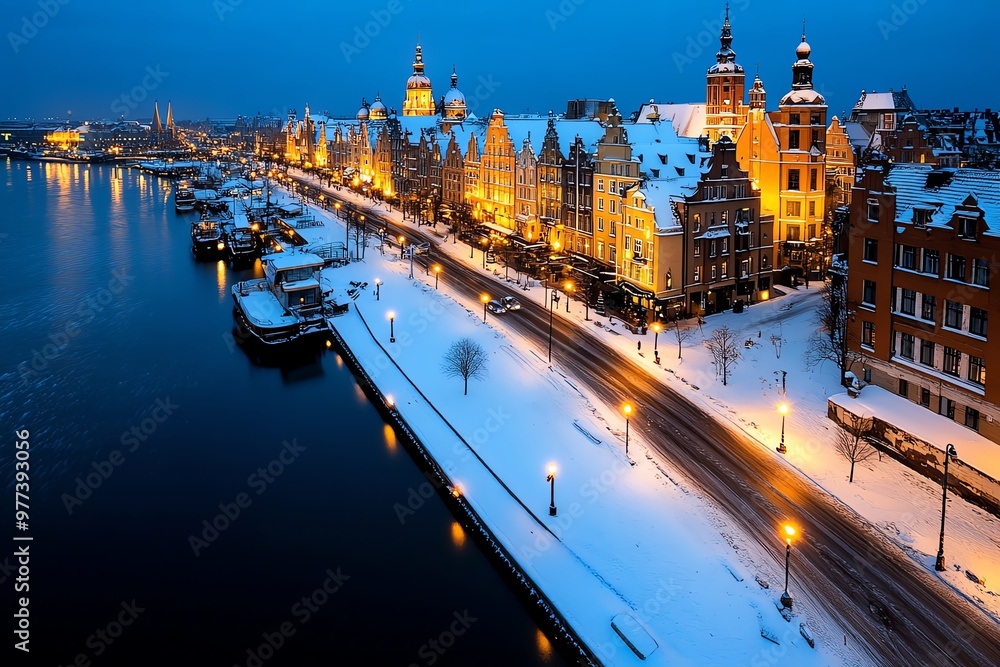 Obraz premium A beautiful winter scene of GdaÅ„skâ€™s Main Town, with snow covering the rooftops and street lamps glowing warmly