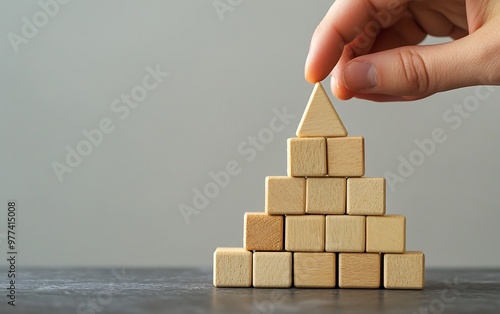 Building Success - Hand Constructing Pyramid with Wooden Cubes in Business Concept. photo