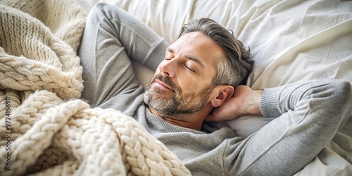 A peaceful male adult lies on his back, eyes closed, surrounded by soft blankets, with a serene expression, in a cozy and calming atmosphere.