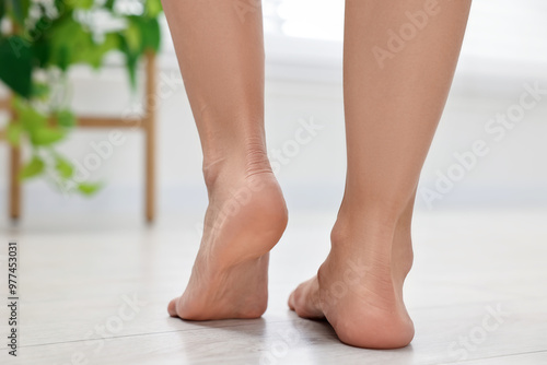 Woman suffering from foot pain at home, closeup