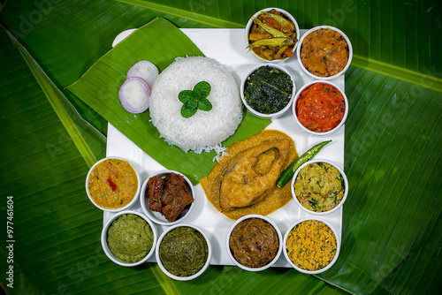 Traditional Bengali dishes such as bhorta, bhaji, fish curry, and vegetable curry are served in white ceramic pots and with Banana leaves.