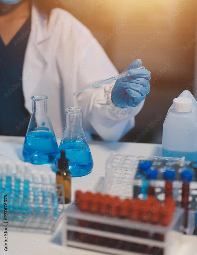 Group of dedicated scientist conduct chemical experiment in medical laboratory, carefully drop precise amount of liquid from pipette into test tube for vaccine drug or antibiotic development. Neoteric Group of dedicated scientist conduct chemical experiment in medical laboratory, carefully drop precise amount of liquid from pipette into test tube for vaccine drug or antibiotic development. Neoteric