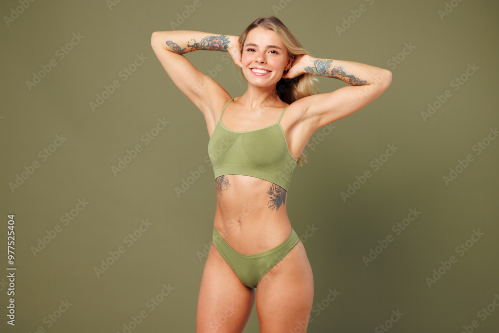 Young nice lady woman with slim skinny body perfect skin wears top bra lingerie stand raise up hands hold head hair look camera isolated on plain pastel green background. Lifestyle diet fit concept. Young nice lady woman with slim skinny body perfect skin wears top bra lingerie stand raise up hands hold head hair look camera isolated on plain pastel green background. Lifestyle diet fit concept.