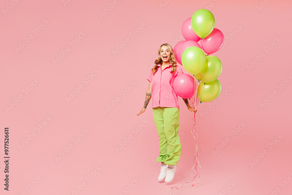 Full body young shocked surprised woman wear shirt celebrating birthday holiday stand hold bunch of colorful air balloons jump high pov fly isolated on plain pastel pink background. Lifestyle concept. Full body young shocked surprised woman wear shirt celebrating birthday holiday stand hold bunch of colorful air balloons jump high pov fly isolated on plain pastel pink background. Lifestyle concept.