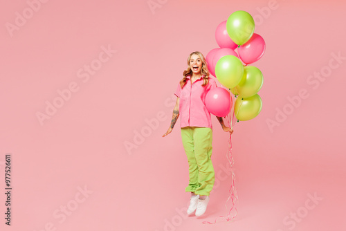 Full body young shocked surprised woman wear shirt celebrating birthday holiday stand hold bunch of colorful air balloons jump high pov fly isolated on plain pastel pink background. Lifestyle concept.