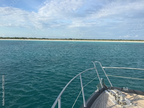 bow of a yacht approaching a desert island