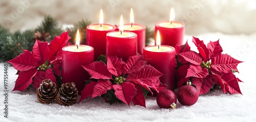 Holiday candles and poinsettias in a Christmas setting, isolated on white.