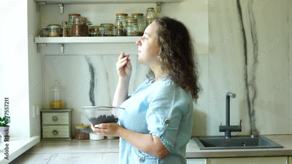 Woman eats blueberries indoor at the kitchen, natural vitamins
Woman eats blueberries indoor at the kitchen, natural vitamins