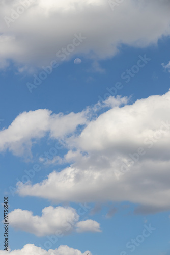 A beautiful blue sky adorned with fluffy white clouds, perfect for creating a serene and tranquil atmosphere.