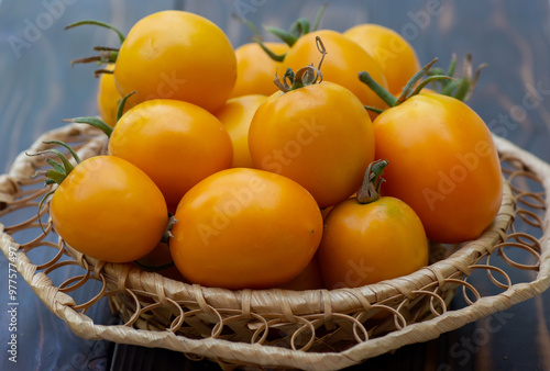 Orange, yellow tomatoes in a wicker basket