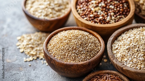 A variety of whole grains in bowls, including brown rice, quinoa, bulgur, and oats, set against a neutral background.